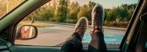 A person showing shoes out of car window